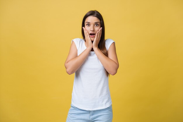 Surprised teenage girl show shocking expression with something. Isolated on Bright Yellow Background. Copy space.