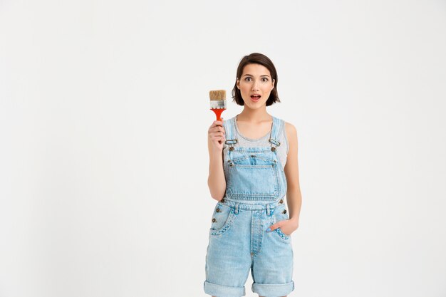 Free photo surprised woman builder with painting brush