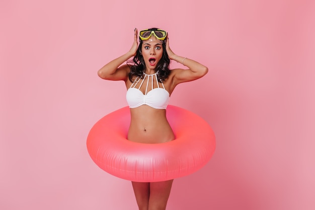 Surprised woman in goggles and bikini looking at front
