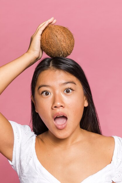 Удивленная женщина с кокосом на голове