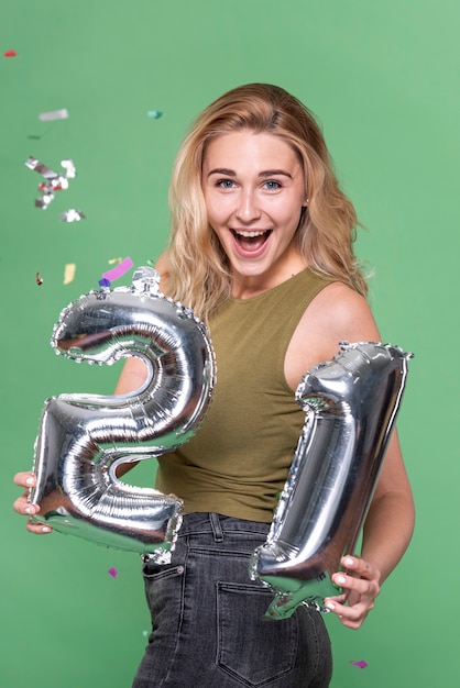 Free photo surprised woman holding a 21 balloon sign