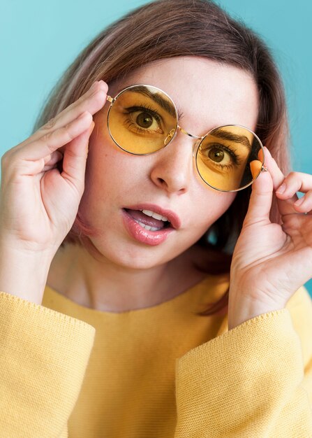 Surprised woman holding glasses close up