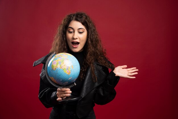 Surprised woman holding globe.