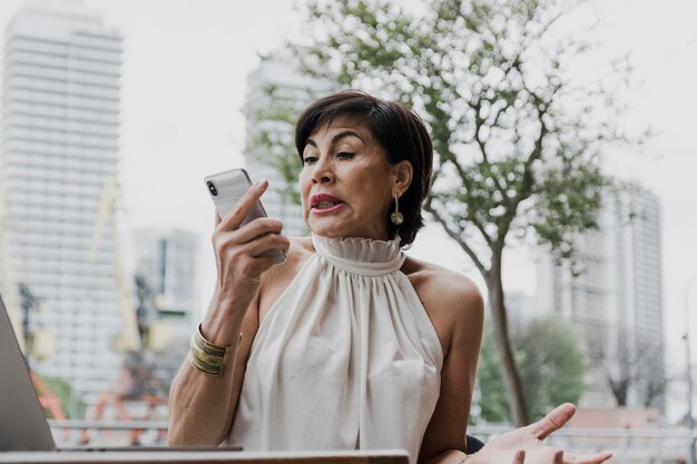 Surprised woman holding a phone medium shot