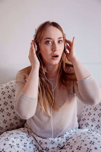 Surprised woman listening to music