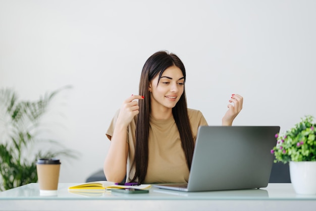 Surprised woman looking computer screen indoor Excited girl chatting on laptop computer Happy businesswoman closing face in front of notebook in home office