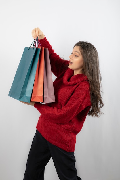 A surprised woman looking at her shopping bags . 