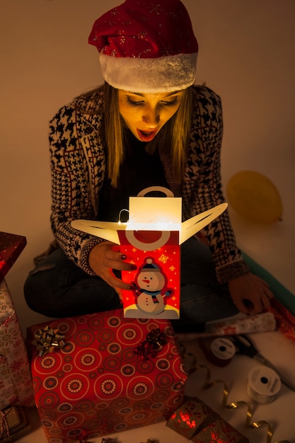 Free photo surprised woman looking into gift box