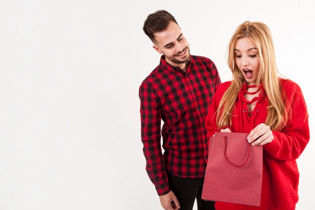 Surprised woman looking at present from man