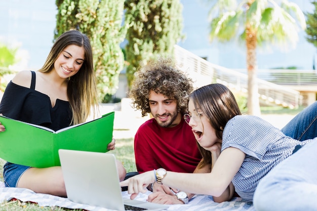 Surprised woman pointing at laptop screen for friends