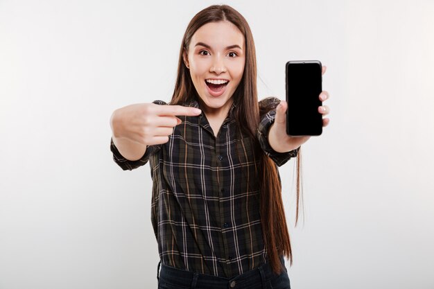 Удивленная женщина показывает пустой экран смартфона
