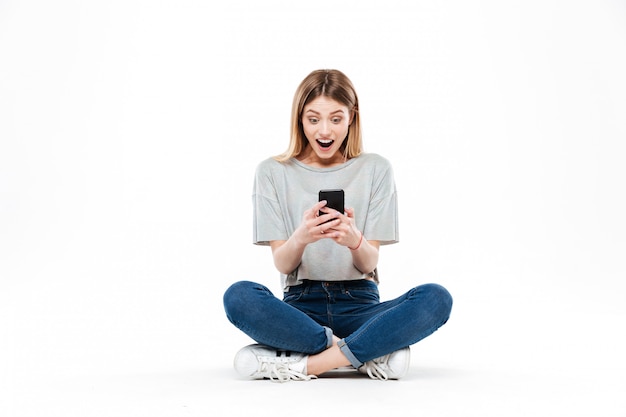 Surprised woman using smartphone