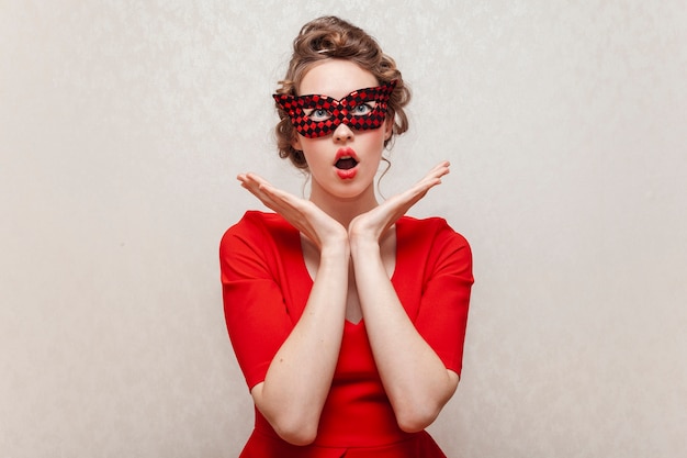 Surprised woman wearing a carnival mask