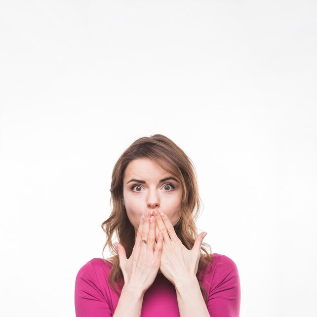 Surprised woman with hand over mouth on white background