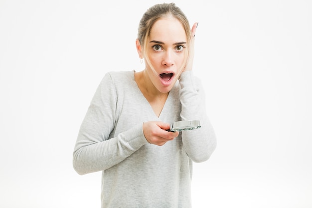 Surprised woman with magnifying glass