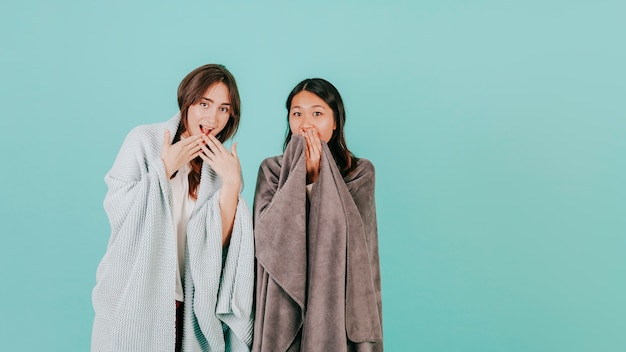 Free photo surprised women in blankets