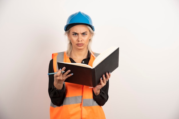 Surprised worker holding notebook on white background. High quality photo