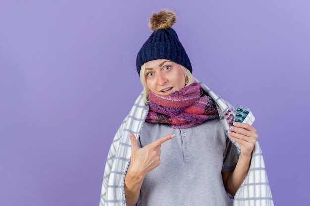 Surprised young blonde ill slavic woman wearing winter hat