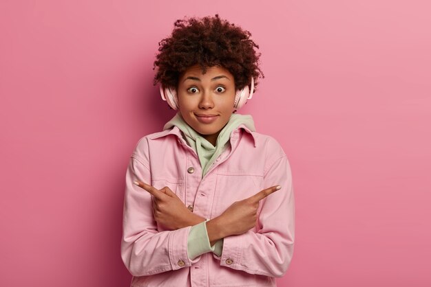 Surprised young dark skinned woman crosses hands over chest