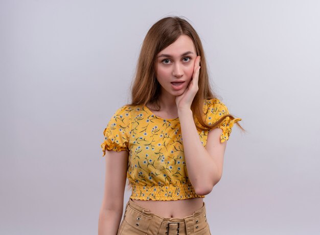 Surprised young girl putting hand on face on isolated white wall with copy space