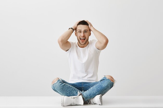 Surprised young guy with glasses posing