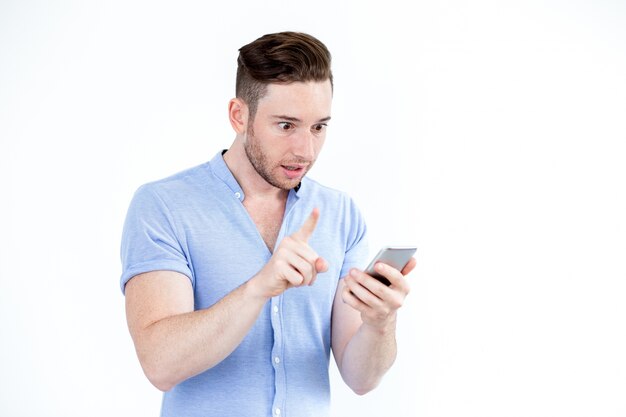 Surprised young man networking on smartphone