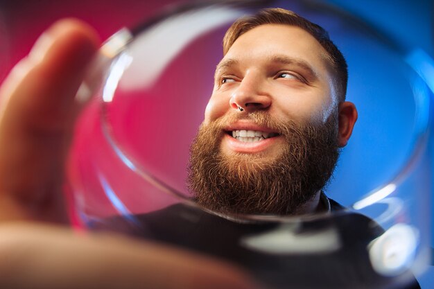 The surprised young man posing with glass of wine.