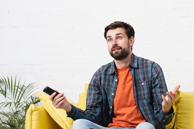 Surprised young man sitting on sofa