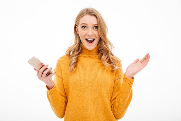 Free photo surprised young woman using mobile phone.