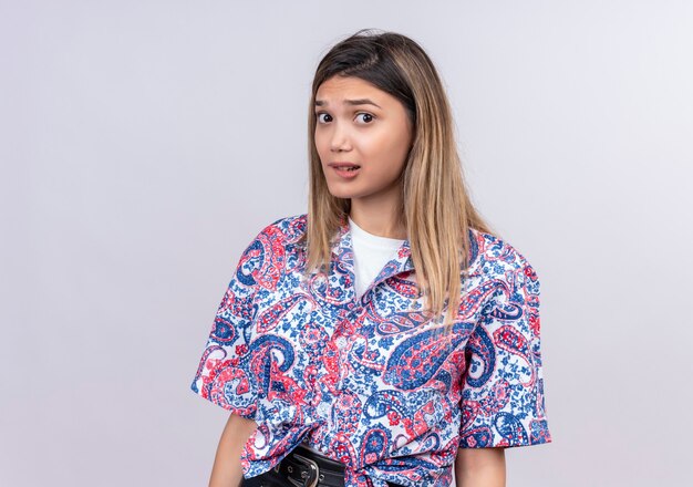 A surprising beautiful young woman wearing paisley printed shirt