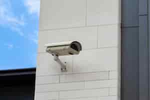 Бесплатное фото Камера видеонаблюдения встроена в каменную стену здания.