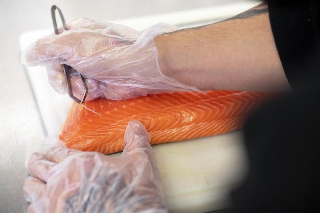 Sushi chef. Close up of mans hands cutting fish for sushi