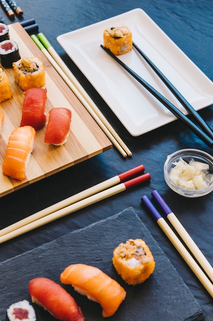 Суши и палочки для еды возле имбиря