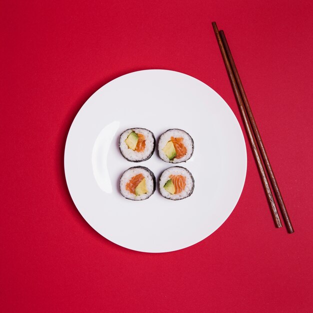 Sushi and chopsticks on red