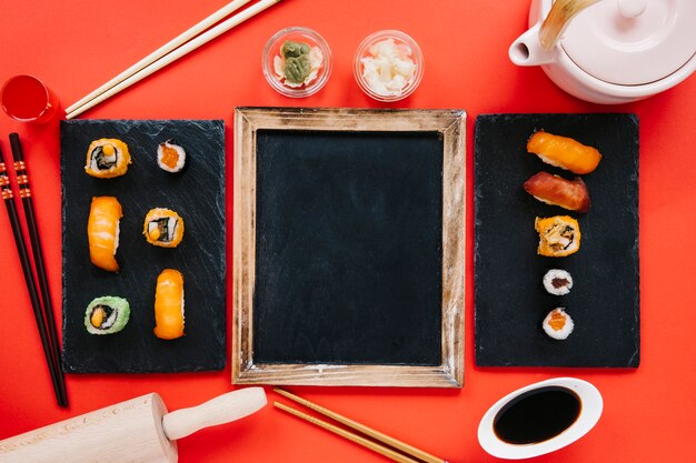 Sushi and condiments around blackboard