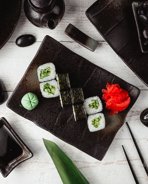 Free photo sushi nori with ginger and wasabi in black plate.