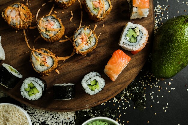 Sushi roll set on the desk topped with sauce top view