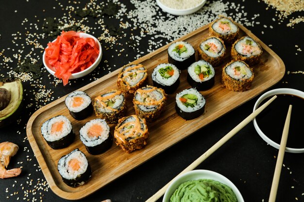 Sushi roll set on the desk topped with sauce top view