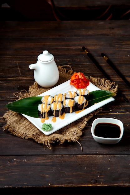 Sushi rolls on leave with topping and soy sauce