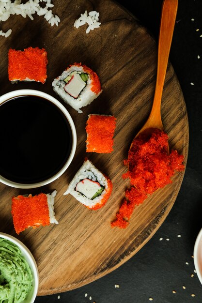 Sushi rolls served on wooden plate with classic ingredients top view