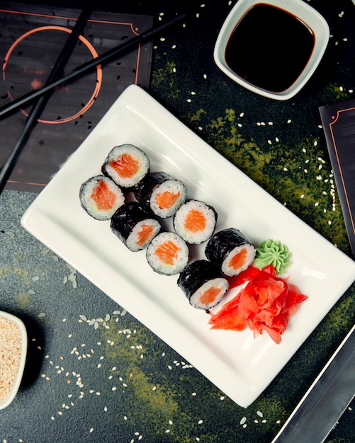 Foto gratuita rotoli di sushi sul piatto quadrato