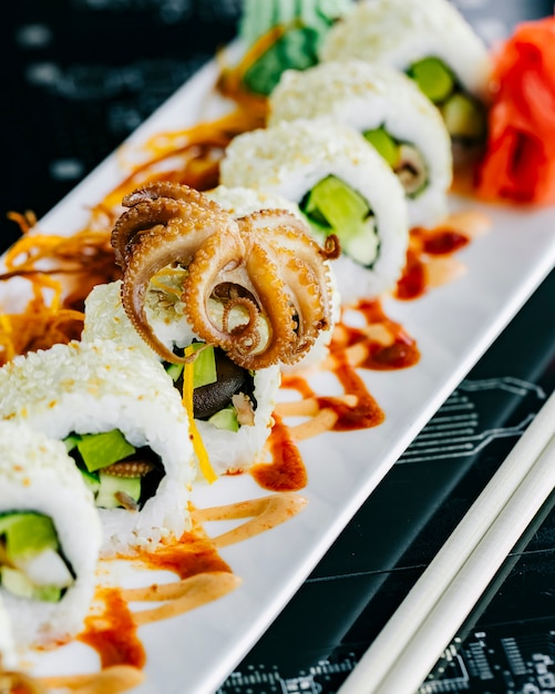 Sushi rolls with baby octopus avocado topped with sesame