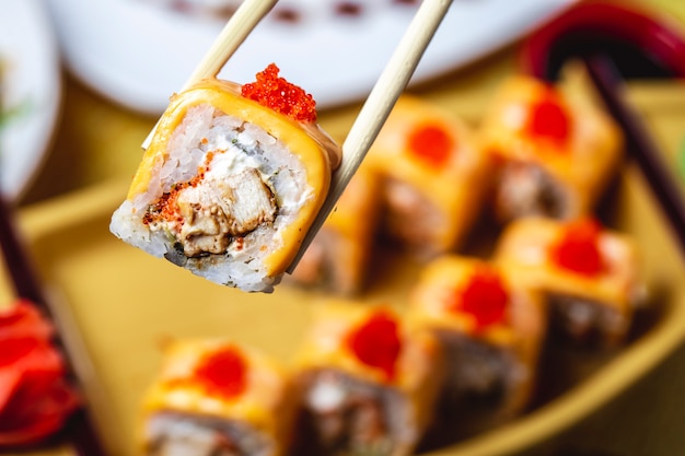 Foto gratuita rotoli di sushi con la vista laterale del fungo del caviale rosso del riso del formaggio cremoso del pollo