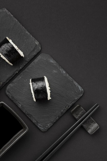 Sushi rolls with chopsticks on slate