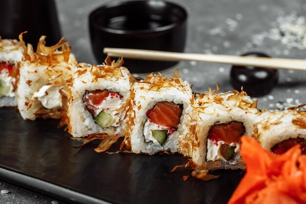 Sushi rolls with cream cheese fried salmon tuna shavings or dried bonito cucumber nori chopsticks ho...