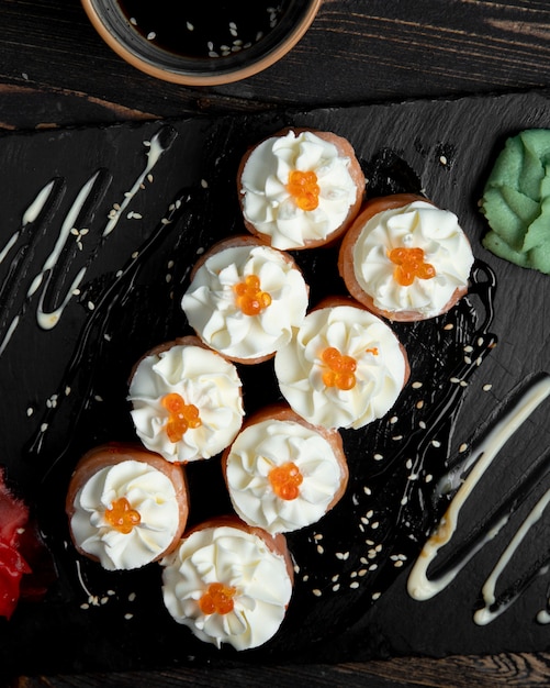 Sushi rolls with cream and red caviar served with ginger and wasabi