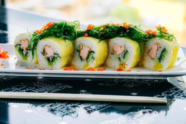 Foto gratuita rotoli di sushi con salmone fritto e cetriolo conditi con alghe