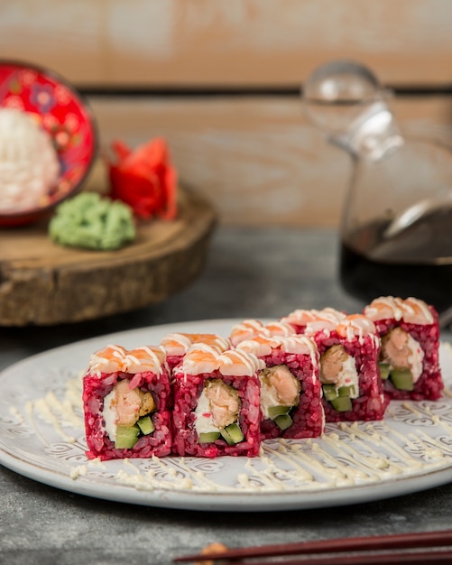 Sushi rolls with pink rice and cream cheese.