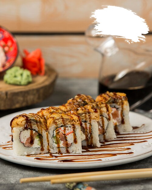 sushi rolls with soy sauce inside white plate.