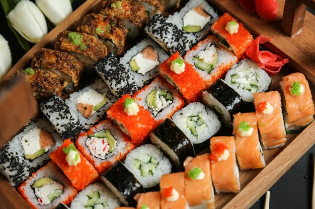 Sushi set with avocado, salmon, crab, sesame seeds, ginger and wasabi